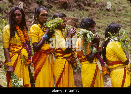 A line of line of South India women wait in line to participate in a fire walking festival in the state of Tamil Nadu. Fire walking is an important ritual practiced by certain sections of Hindu society. The ritual is practiced by many Hindus in south India. The ritual is primarily dedicated to Amman an important female deity associated with the Shakti cult in South Indian and Tamil culture. The fire walking ritual is an act of self-purification. For some of these devotees it is part of a vow in which the devotee promises to walk on fire in exchange for a wish or a blessing by Amman. Stock Photo