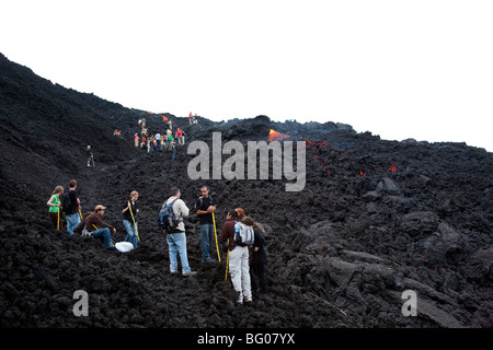 Flowing Lava and Tourists towards the Pacaya Volcano Peak. Volcan Pacaya National Park. Stock Photo