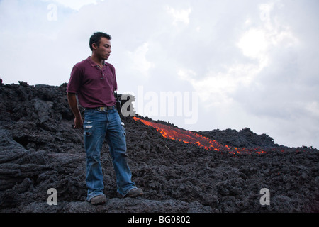 Flowing Lava and Tourist Guide towards the Pacaya Volcano Peak. Volcan Pacaya National Park. Stock Photo