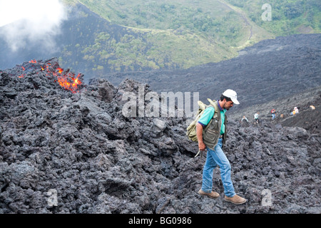 Flowing Lava and Tourist Guide towards the Pacaya Volcano Peak. Volcan Pacaya National Park. Stock Photo