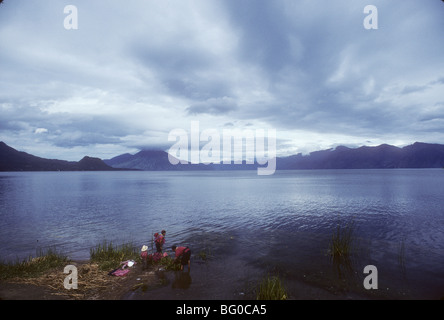 Women take their children with them as the wash clothes in Lake Atitlan, near San Pedro, Guatemala Stock Photo