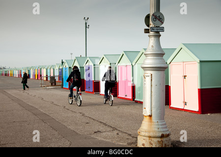 People cycling along a promenade in contravention of a 'No Cycling' prohibition - even passing a sign reminding them. Stock Photo