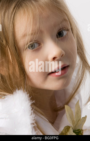 closeup portrait of beautiful little girl with long hair and flower on dress Stock Photo