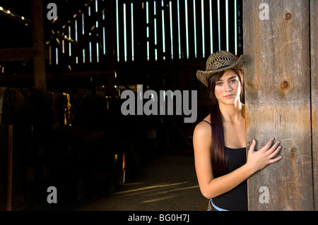 Cowgirl in barn doorway with hat and tank top Stock Photo