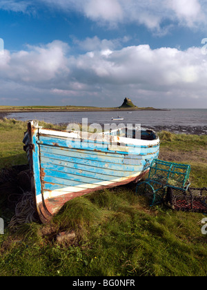 View towards Lindisfarne Castle with old fishing coble and lobster pots, Holy Island, Northumberland, England, United Kingdom Stock Photo