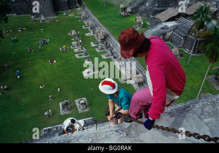 Tourist climbing down front of Temple One, Tikal, UNESCO World Heritage Site, Guatemala, Central America Stock Photo