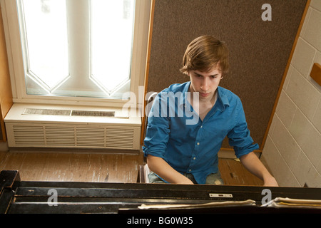 Music student Wade Coufal plays a piano in a practice room at the Oberlin Conservatory of Music on the campus of Oberlin College Stock Photo