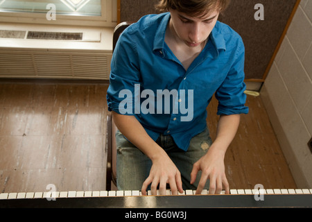 Music student Wade Coufal plays a piano in a practice room at the Oberlin Conservatory of Music on the campus of Oberlin College Stock Photo