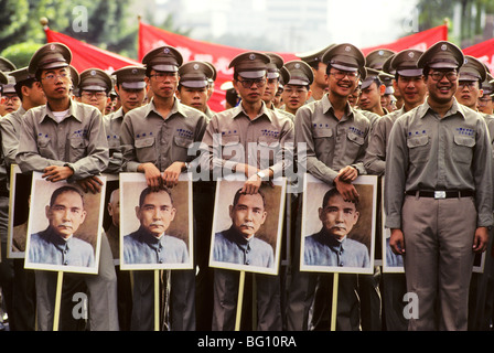 A parade of soldiers carrying images of Sun Yat-sen (the Chinese revolutionary and political leader often referred to as the Father of Modern China. He was the first provisional president when the Republic of China was founded in 1912 and later founded the Kuomintang where he served as its first leader. Sun was a uniting figure in post-imperial China and remains unique among 20th century Chinese politicians for being revered in both Mainland China and Taiwan) in Taipei, Taiwan. Stock Photo