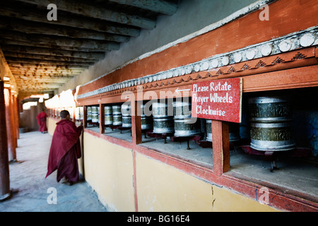 Novice monk, a small boy, spins prayer wheels at Hemis Gompa (Tibetan Buddhist monastery) in Ladakh, India. Stock Photo