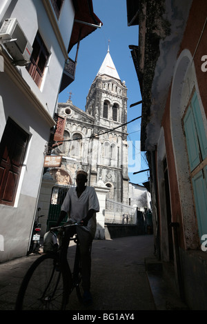 Man on a bicycle in front of St Joseph Cathedral in Stonetown Zanzibar Stock Photo