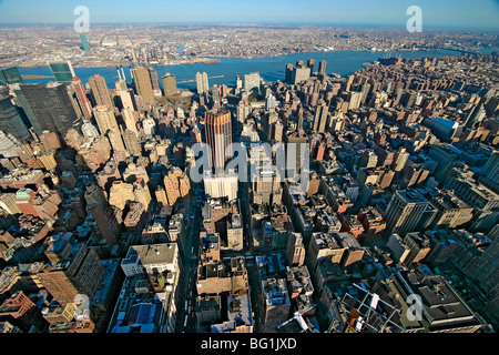 East River seen from top of Empire State Building with shadow of Empire State Building falling on nearby buildings. Manhattan NY Stock Photo