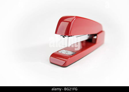 Close-up image of a red stapler on a white background. Stock Photo