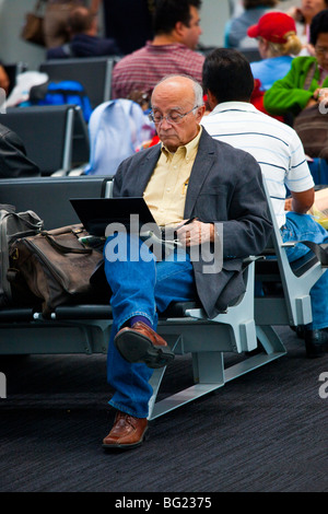Elderly man using WIFI internet in Benito Juarez International Airport in Mexico City Stock Photo