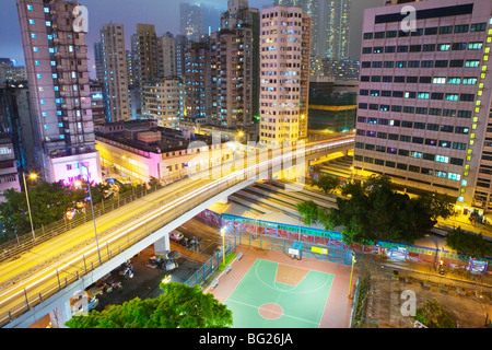 Residential apartment building exteriors, basketball court, night. China, Hong Kong Stock Photo