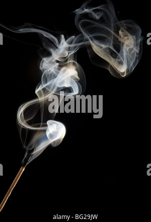 Single match stick being blown out with a wisp of smoke Stock Photo
