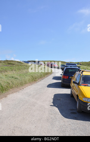 Queue of cars on road side at Northcott beach in Cornwall UK