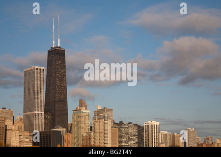 John Hancock Center tower and the skyline of the north of Chicago city against a blue sky with fluffy clouds Stock Photo