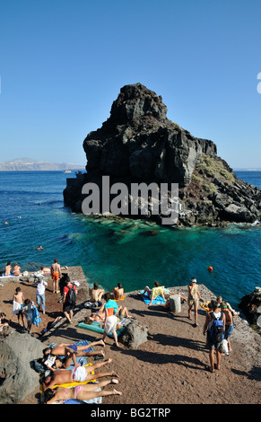 Tourists swimming and sunbathing at Ammoudi bay, near Oia village, Santorini island, Greece Stock Photo