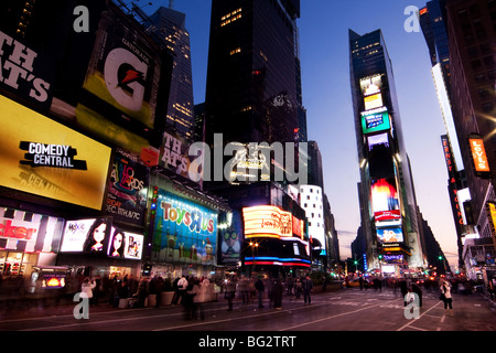 Night scene of Times Square in Manhattan (New York City) with all the lit up billboards and advertisements, and many tourists. Stock Photo