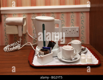 Typical UK hotel bedroom accessory - a kettle with cup and saucers for the purpose of making tea or coffee in the bedroom. Also, Stock Photo