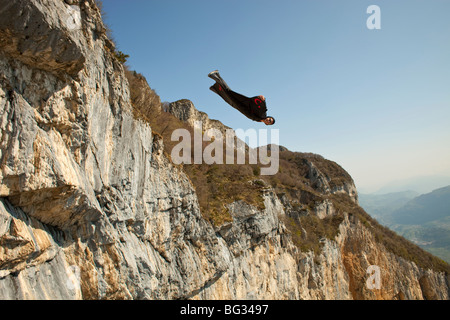 BASE jump from a cliff. The ultimate kick to do an object jump with a wingsuit on and fly proximity along the mountain. Stock Photo