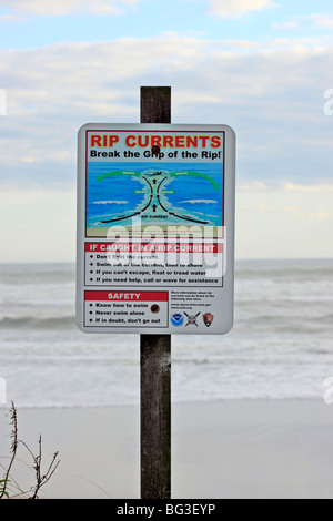 Sign at ocean beach warning of the dangers of rip currents, Long Island, NY Stock Photo