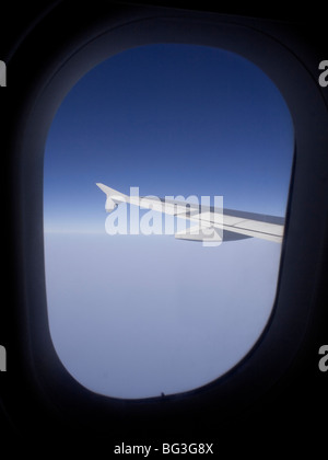 Air travel. Aerial view from the cabin window of an Airbus A319 passenger jet in flight at high altitude, showing the aircraft's wing Stock Photo