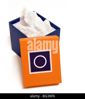An open blue box filled with wrapping white tissue  sits with its orange lid leaning on it. Stock Photo