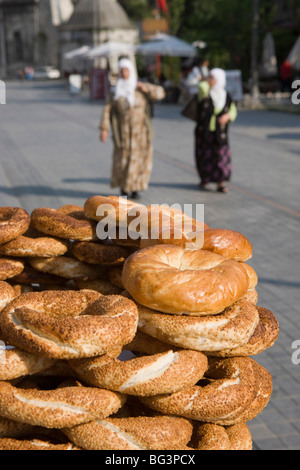 Traditional Turkish bagels with sesame seeds for sale, ladies in traditional costume in distance, Istanbul, Turkey, Europe