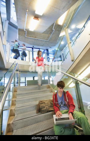 University student using computer on staircase Stock Photo