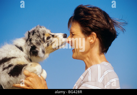 woman and Australian Shepherd dog puppy Stock Photo