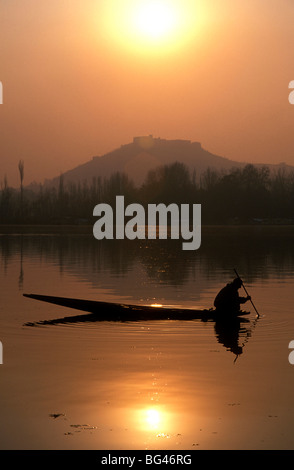 Local fisherman peers into the waters of Nigeen Lake on a winter evening in Srinagar, Indian-administered Kashmir, India, Asia Stock Photo