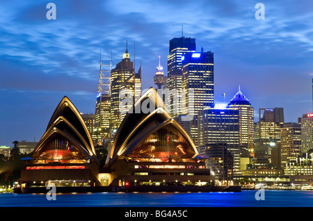 Australia, Sydney, View across Sydney harbour to Sydney Opera House & skyline at dusk Stock Photo