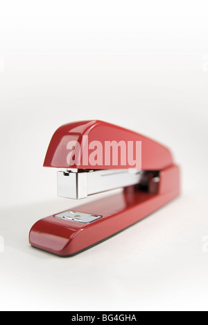 Close-up image of a red stapler on a white background. Stock Photo