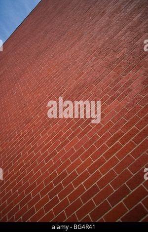 A brick wall taken on an angle, with blue sky in one corner. Stock Photo