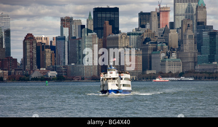 New York City, New York, USA, seen from its harbor. The boat at center is headed for the Statue of Liberty. Stock Photo