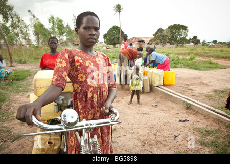 A girl transports water from a well with her bicycle in the town of Amuria in North East Uganda. Stock Photo
