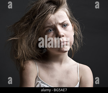 Powerful Shot of a Messy Child against a Grey Background Stock Photo