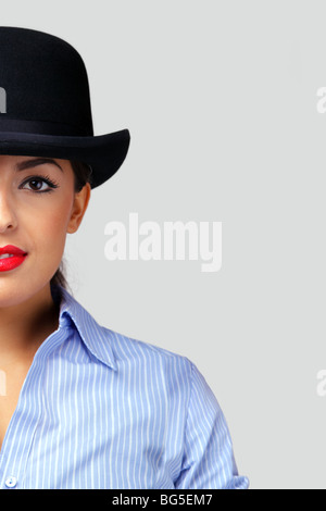 Half frame shot of a businesswoman wearing a bowler hat, looking at camera. Stock Photo