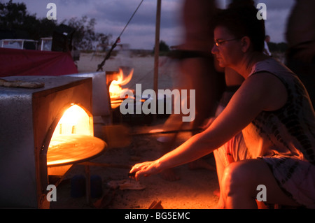 Baking pita bread in a stone oven - Tabun night shot Stock Photo