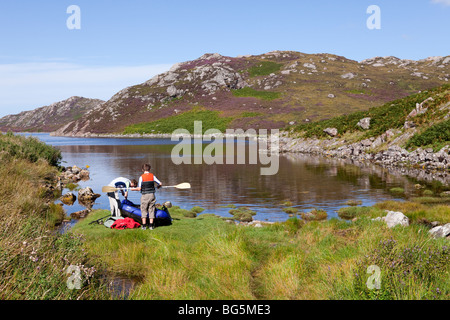 Two brothers setting out in a double inflatable canoe on Loch A Chadh-fi from Skerricha, Highland, Scotland Stock Photo