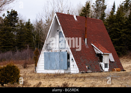 Small abandoned A-frame house. Stock Photo