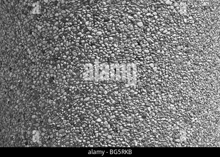 Textured pebble facade on a vertical column. Stock Photo