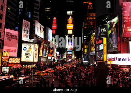 Neon signs and yellow taxi cabs light up Times Square in New York USA - Stock Photo