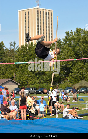 Teenage boy pole vaulter clearing the bar during the Bluegrass State Games in Lexington, Kentucky USA Stock Photo