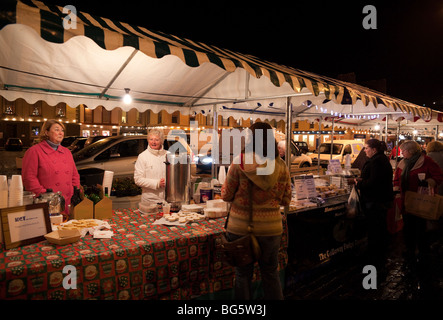 Pre Christmas late shopping in Scottish town of Kelso farmers market with stalls round the tree in the square December Stock Photo