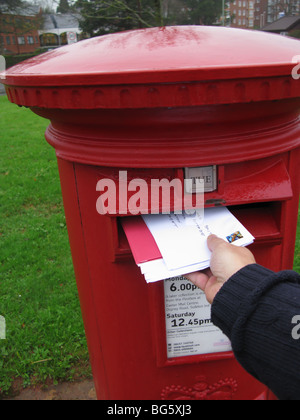 hand posting a letter to a traditional English post box Stock Photo - Alamy