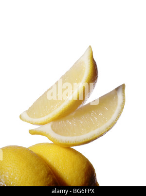 Lemon wedges and lemons on white Stock Photo