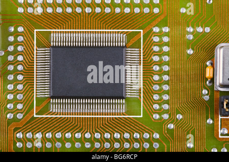 Small microcircuit soldered to an electronic plate near to other components Stock Photo